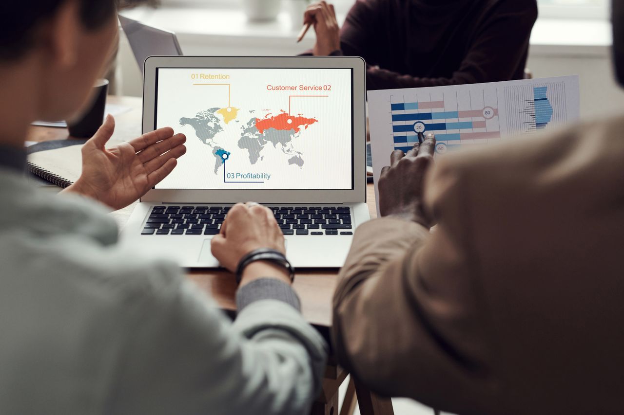 Mastering the First Impression: Your intriguing post title goes here Team collaborating on business strategy with laptop displaying global analytics.
